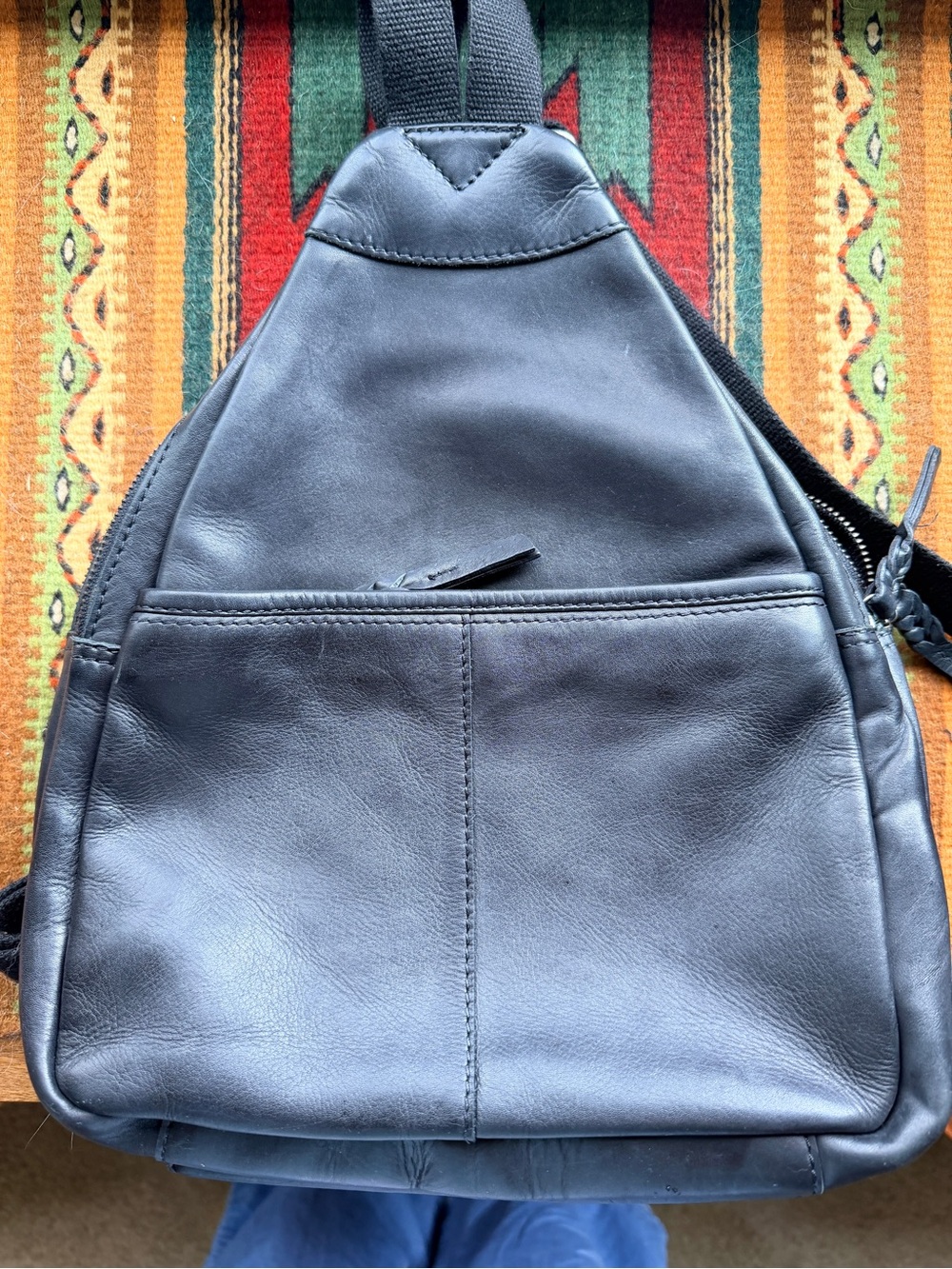 Black trianglular leather backpack with multiple pockets